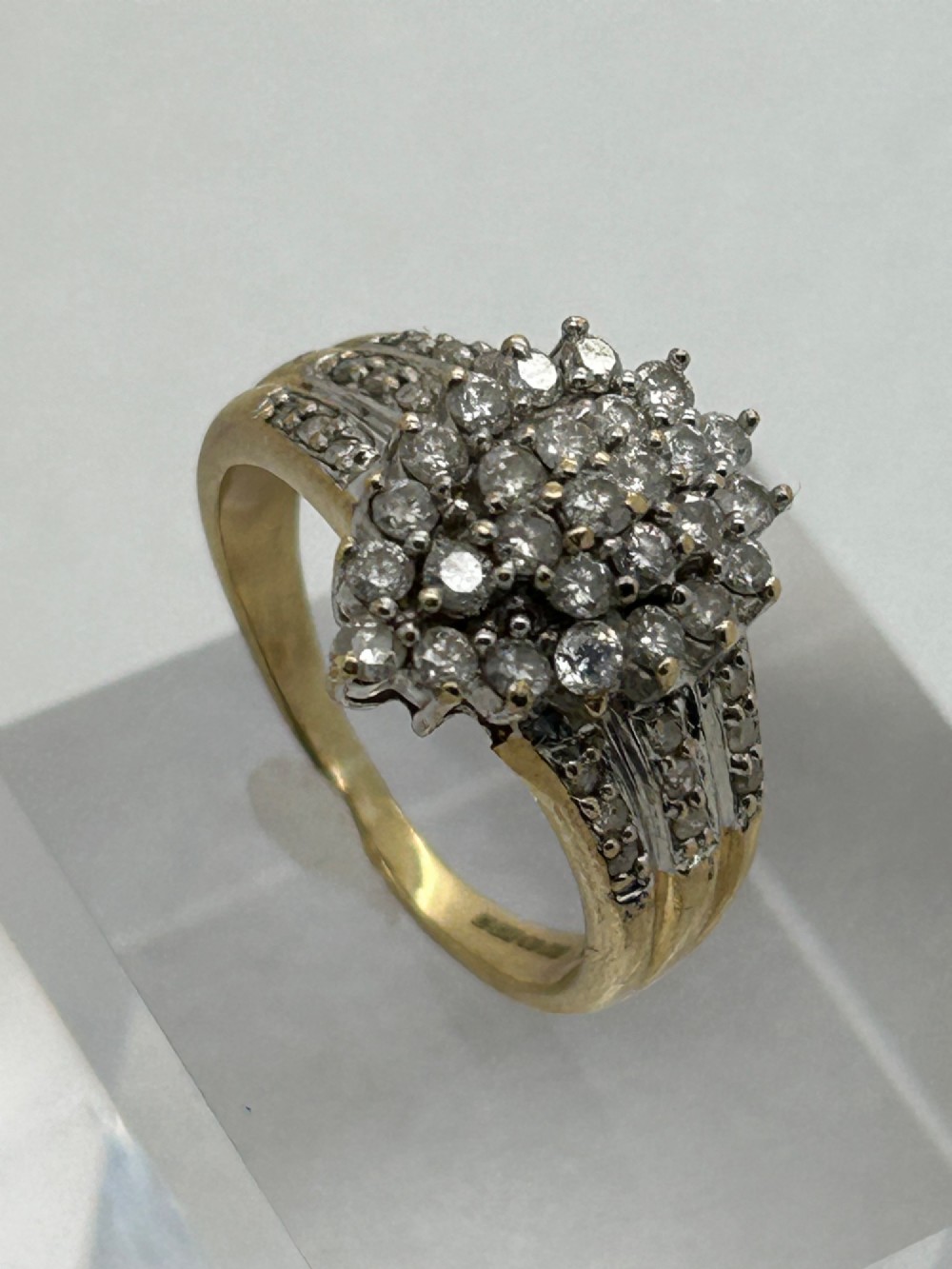 A yellow gold band ring features a central teardrop-shaped cluster of small round diamonds with additional pave diamonds set into the shoulders. View IV
