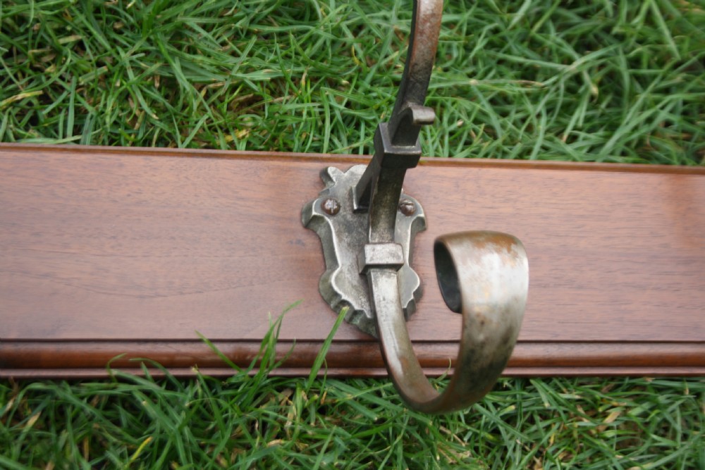 Five Edwardian coat-hooks mounted on walnut View II