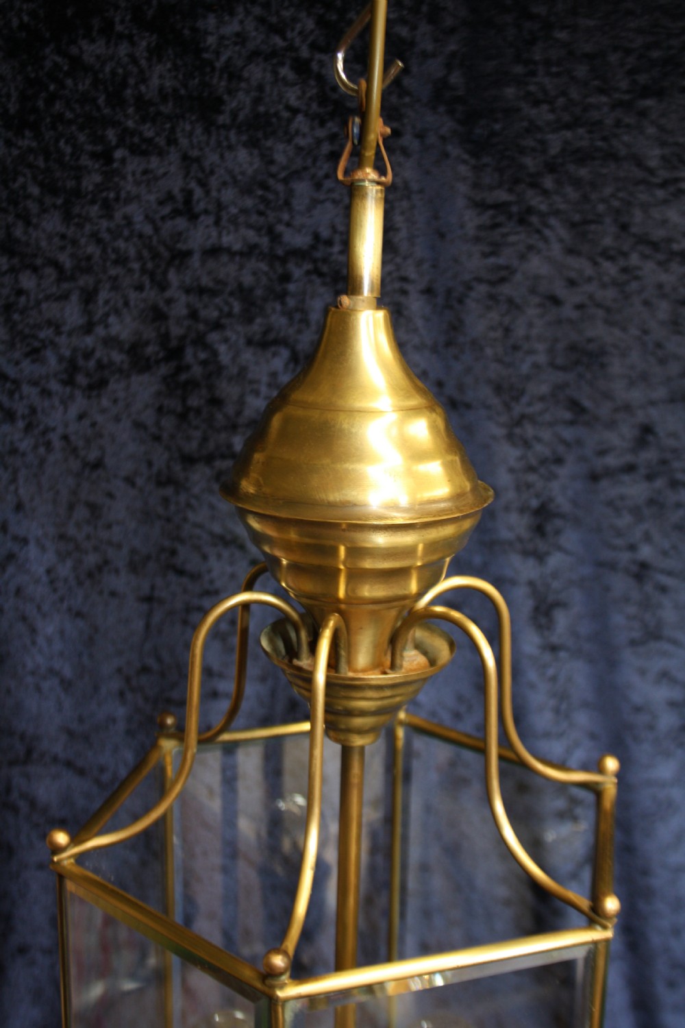 An early twentieth-century hexagonal brass hall lantern featuring six clear glass panels and a central light fixture suspended from a hooked top. View IV