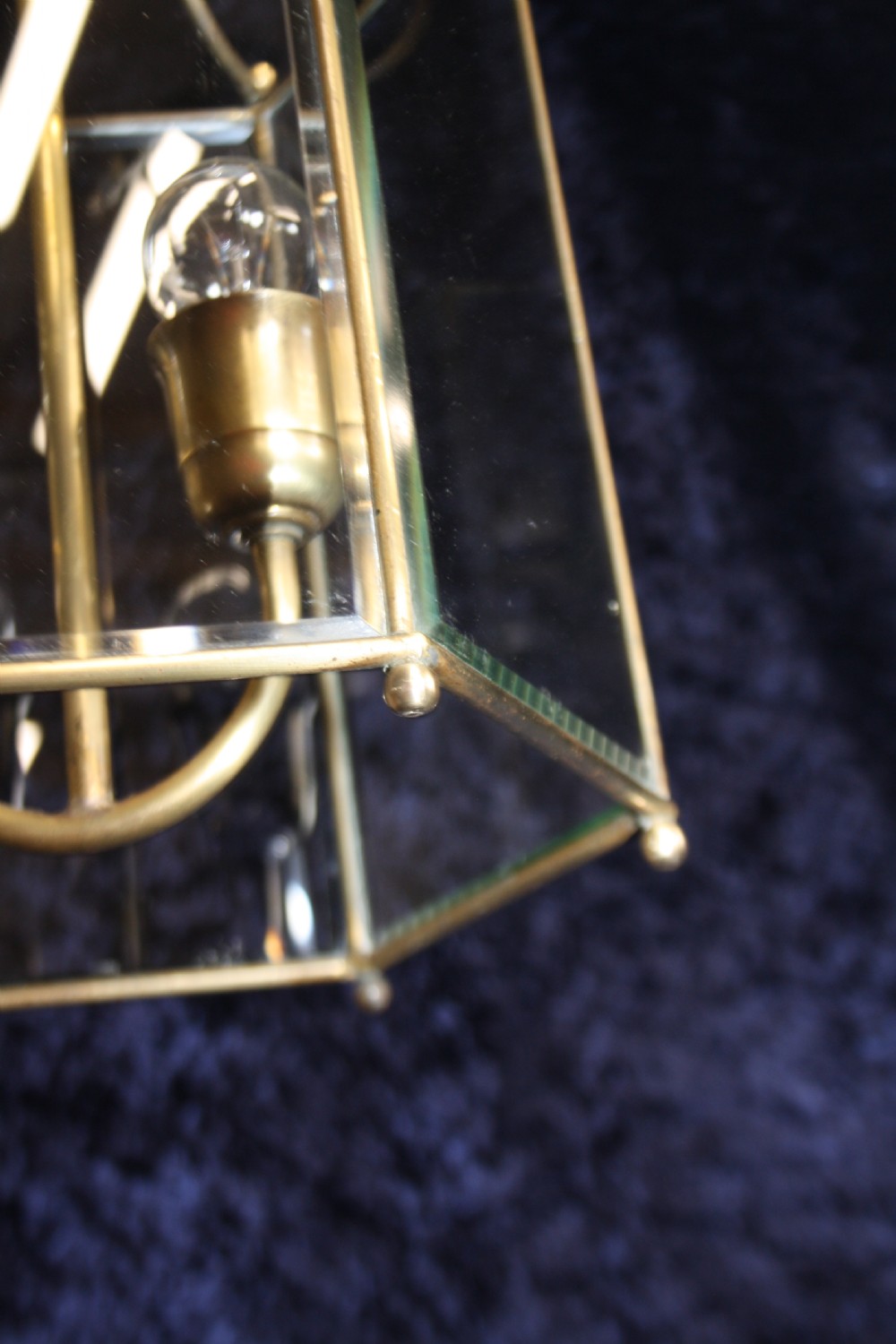 An early twentieth-century hexagonal brass hall lantern featuring six clear glass panels and a central light fixture suspended from a hooked top. View VII