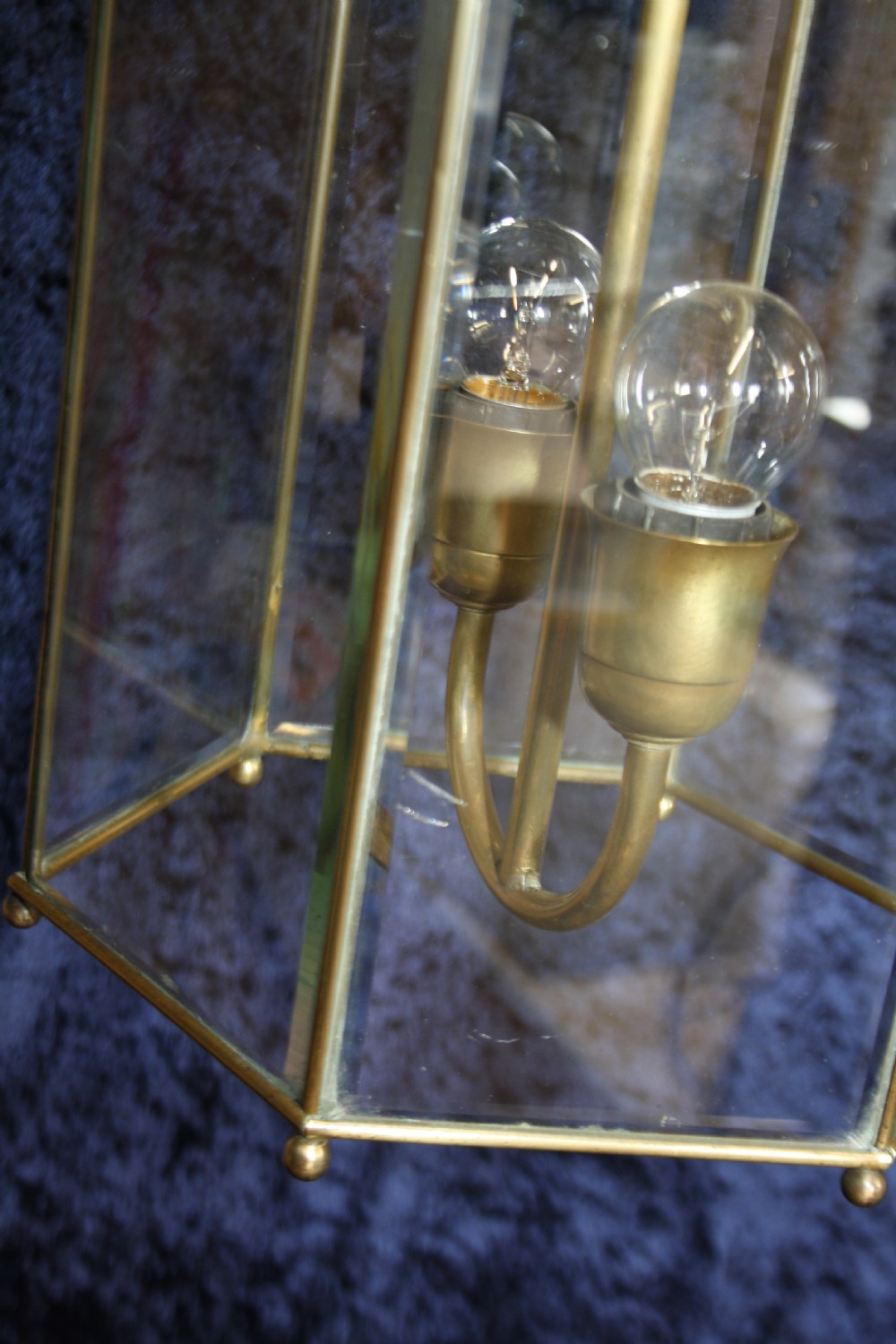 An early twentieth-century hexagonal brass hall lantern featuring six clear glass panels and a central light fixture suspended from a hooked top. View VIII