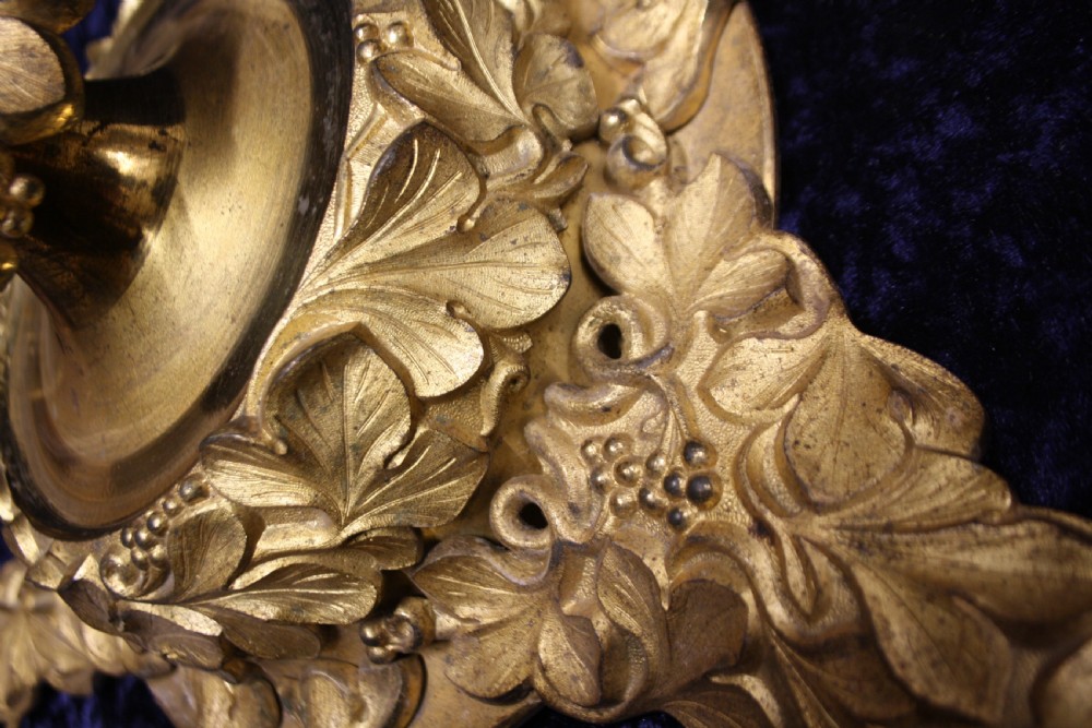 An ornate cast gilt brass ceiling rose featuring three foliate arms, grape and leaf motifs, and a central mounting hook. View V