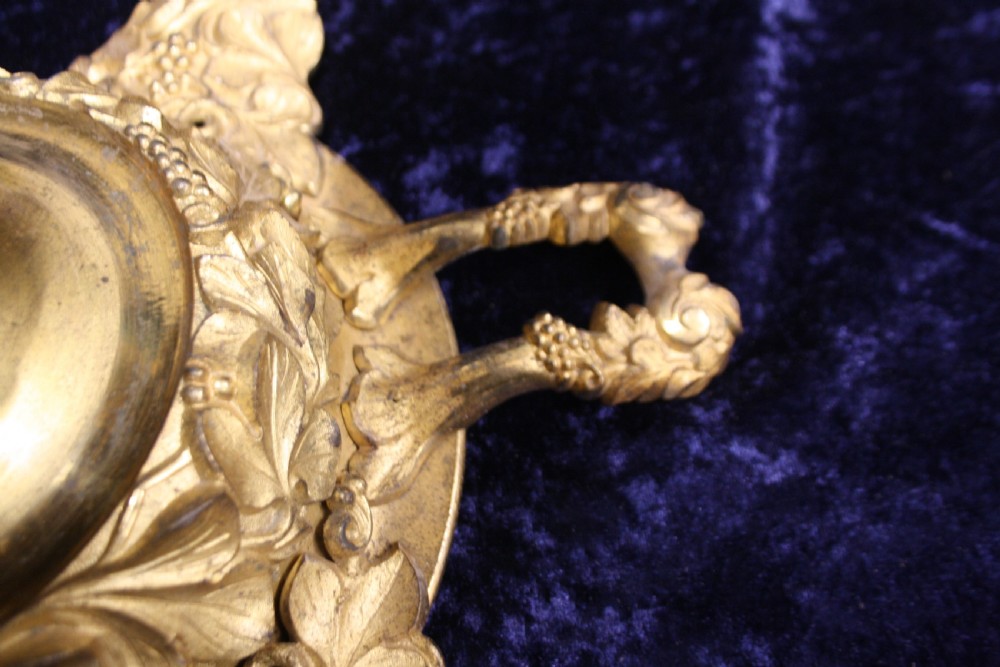 An ornate cast gilt brass ceiling rose featuring three foliate arms, grape and leaf motifs, and a central mounting hook. View VI