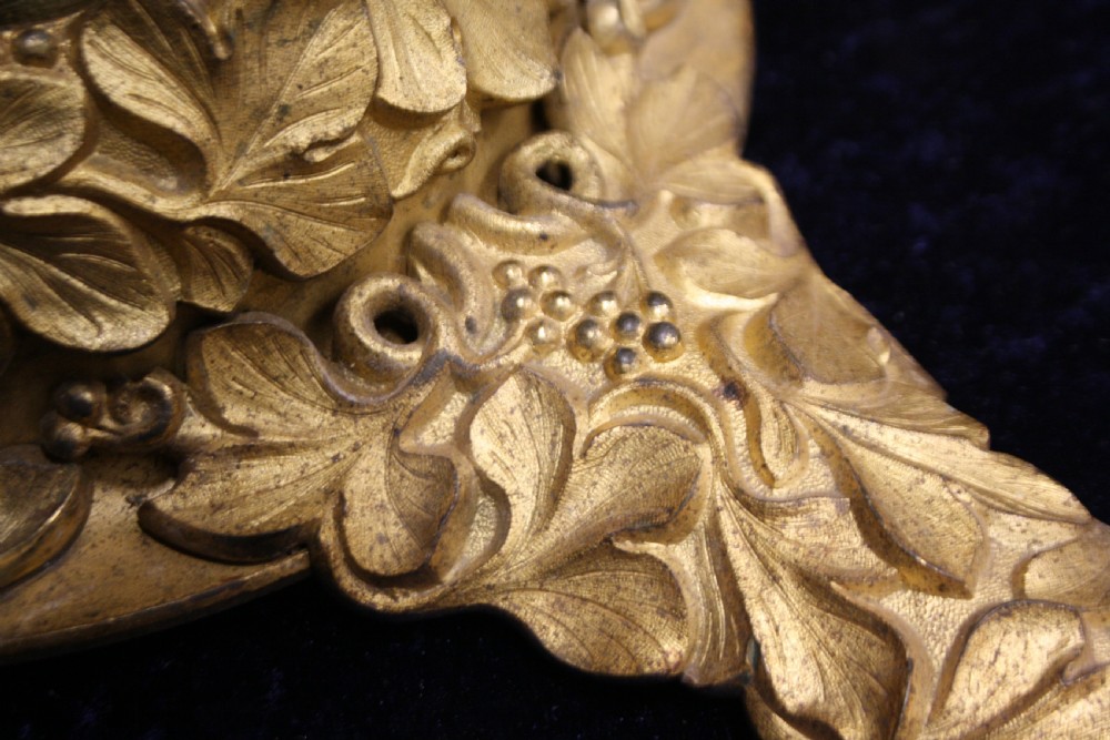 An ornate cast gilt brass ceiling rose featuring three foliate arms, grape and leaf motifs, and a central mounting hook. View VIII