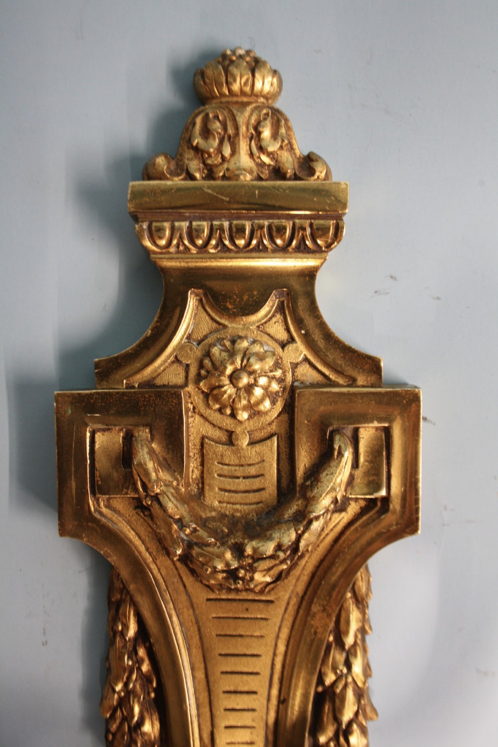 A pair of early 20th-century cast brass twin-arm wall sconces featuring Neoclassical garland and wreath embellishments. View VIII