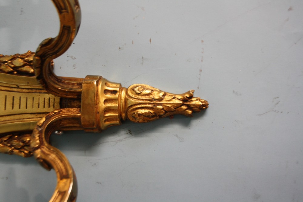 A pair of early 20th-century cast brass twin-arm wall sconces featuring Neoclassical garland and wreath embellishments. View IX