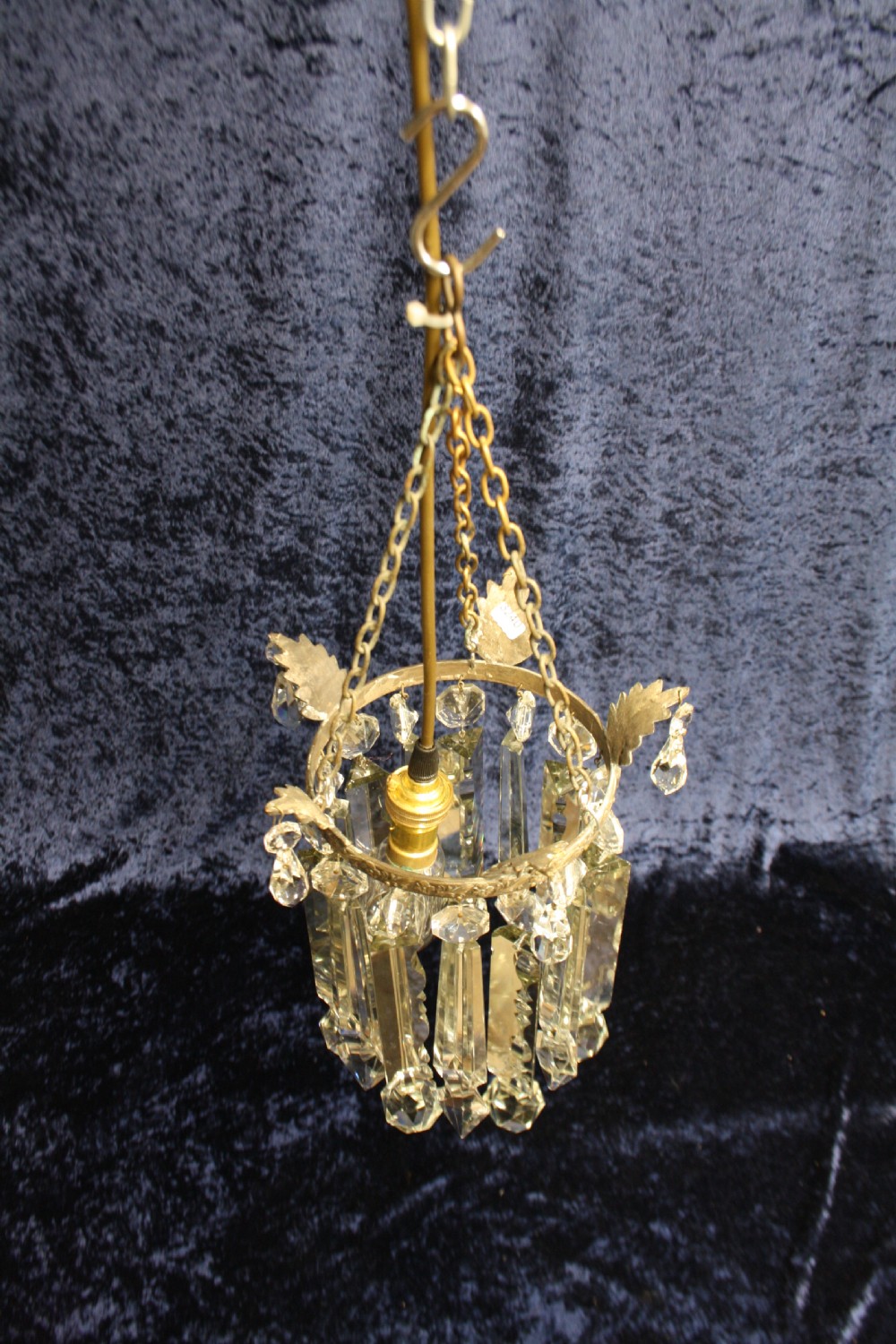 An early 20th century ceiling pendant featuring vertical glass prism lustres suspended from a brass gallery ring and hanging chain. View III