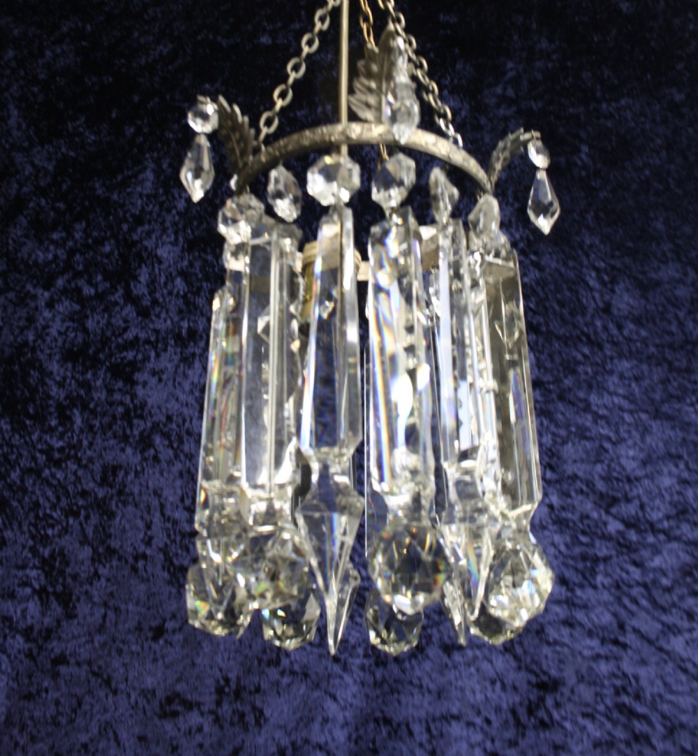 An early 20th century ceiling pendant featuring vertical glass prism lustres suspended from a brass gallery ring and hanging chain. View V