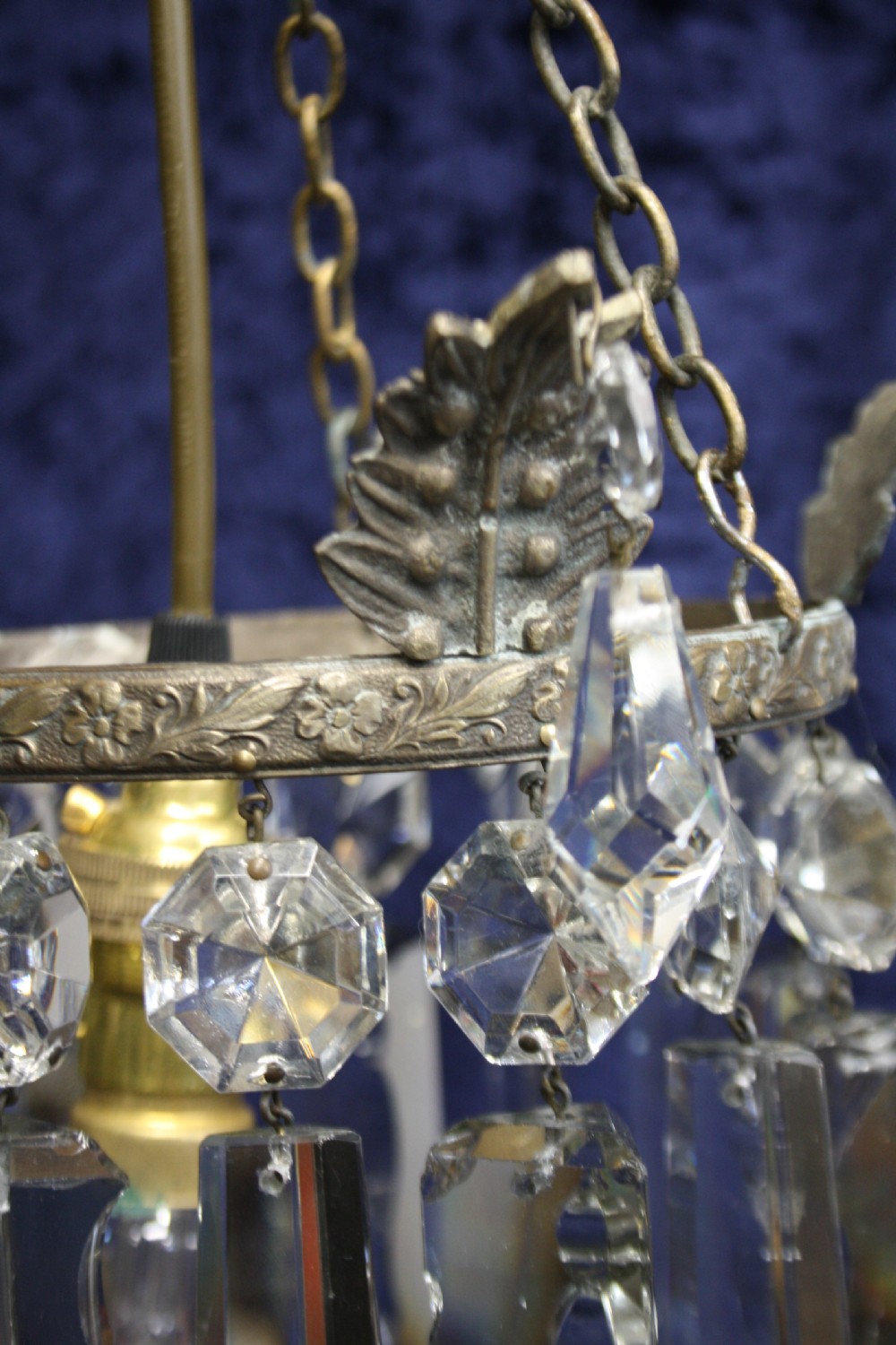 An early 20th century ceiling pendant featuring vertical glass prism lustres suspended from a brass gallery ring and hanging chain. View VI
