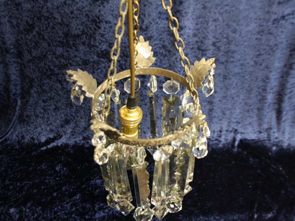 An early 20th century ceiling pendant featuring vertical glass prism lustres suspended from a brass gallery ring and hanging chain. View IX
