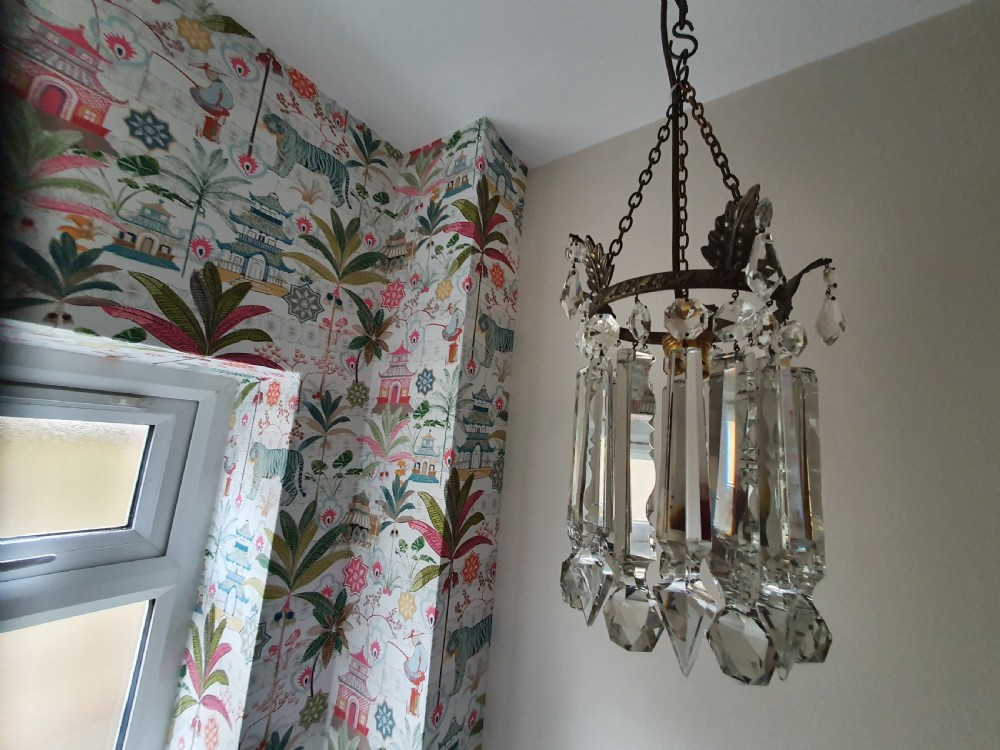 An early 20th century ceiling pendant featuring vertical glass prism lustres suspended from a brass gallery ring and hanging chain. View X