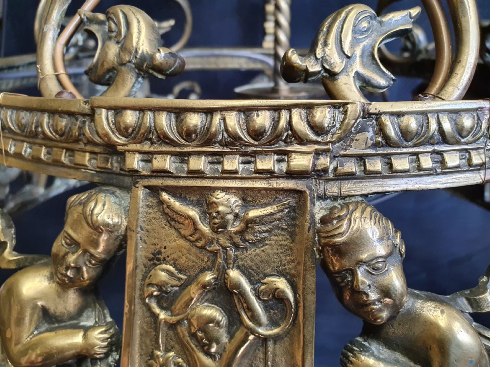 An Edwardian brass four-light chandelier featuring cast cherub figures, decorative swags, and a green fabric shade with hanging fringe. View VIII