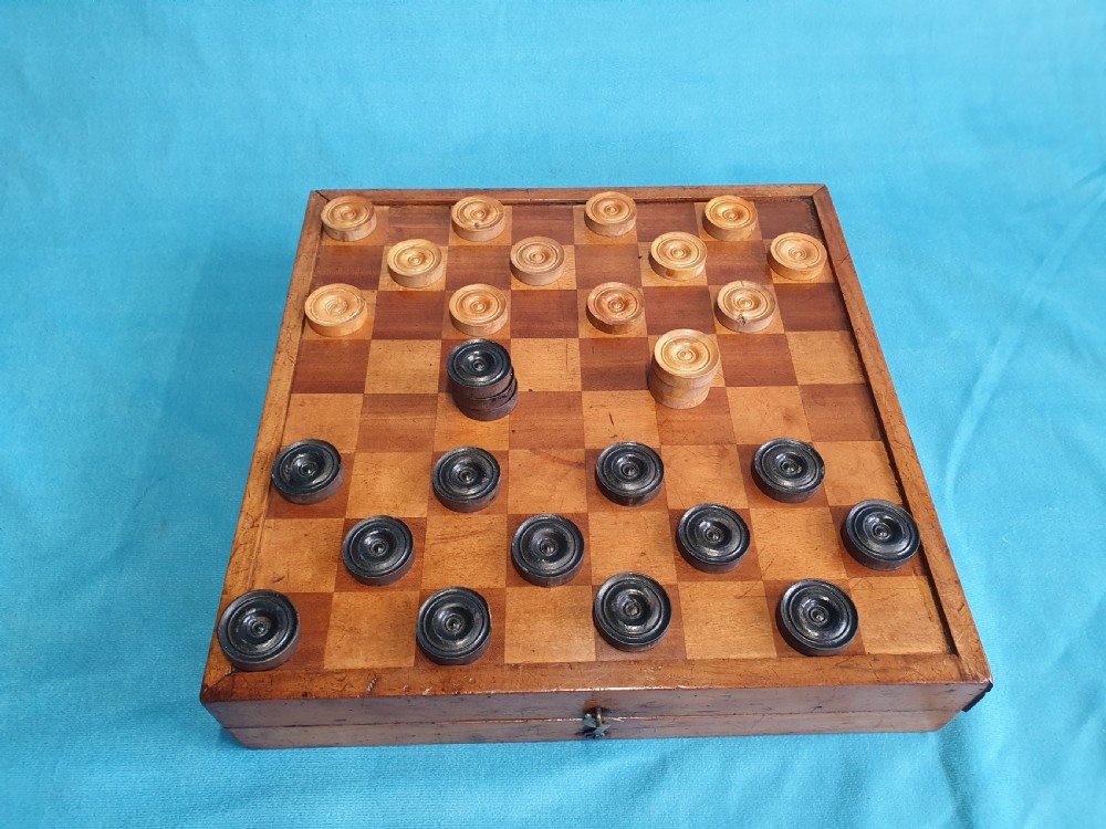 A Victorian wooden folding chess board box displaying full black and natural boxwood Staunton pattern chess pieces. View VII