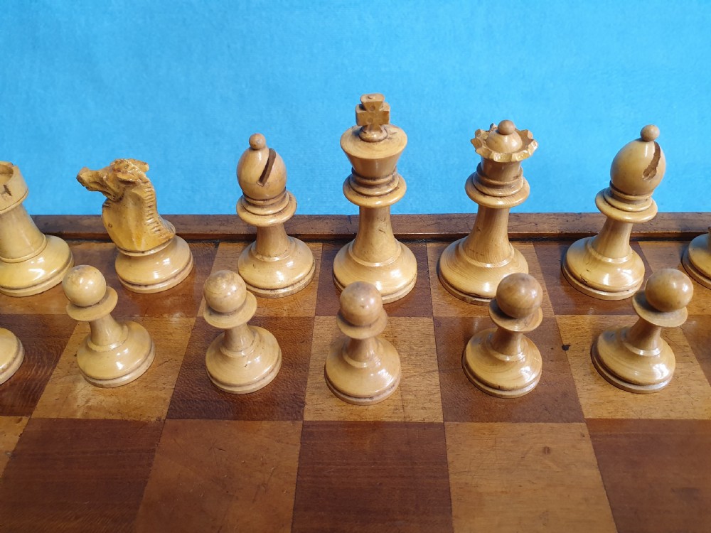 A Victorian wooden folding chess board box displaying full black and natural boxwood Staunton pattern chess pieces. View XII