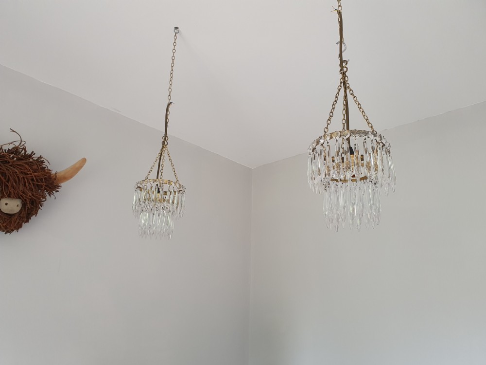 A pair of early 20th-century small ceiling pendants featuring circular brass frames draped with tiers of pointed clear crystal spike drops. View VI