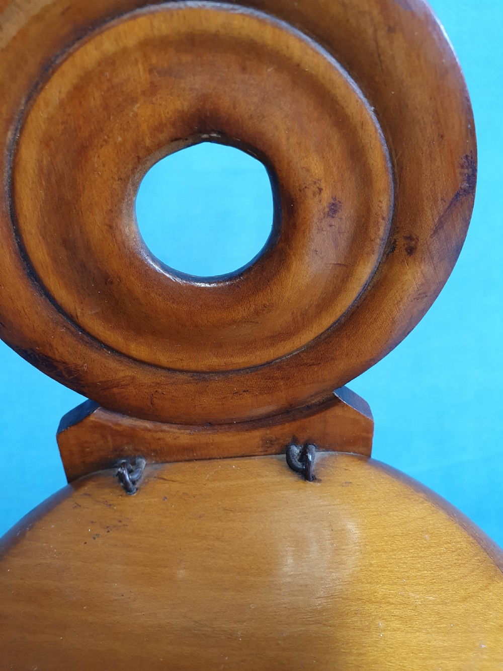 A mid-19th-century turned wooden wall-hanging salt box with staved multi-tone timber construction, a circular hinged lid, and a pierced round backboard. View III