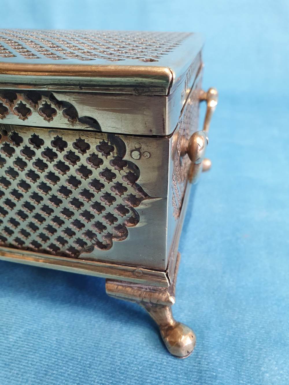 A late nineteenth-century rectangular brass jewellery box featuring pierced lattice fretwork, small corner feet, and a front keyhole. View II