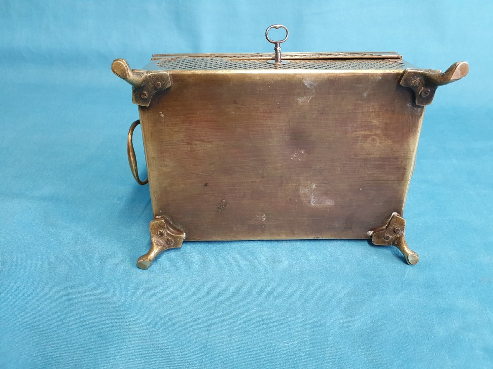 A late nineteenth-century rectangular brass jewellery box featuring pierced lattice fretwork, small corner feet, and a front keyhole. View V