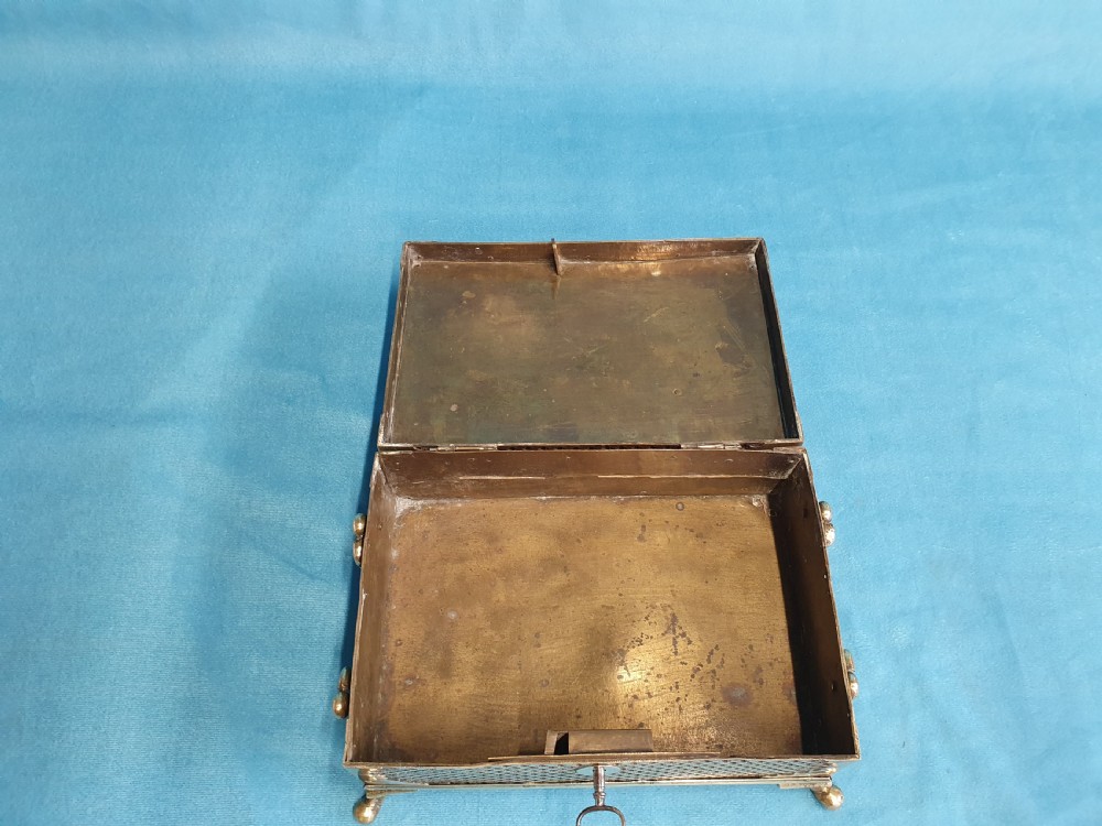 A late nineteenth-century rectangular brass jewellery box featuring pierced lattice fretwork, small corner feet, and a front keyhole. View VI