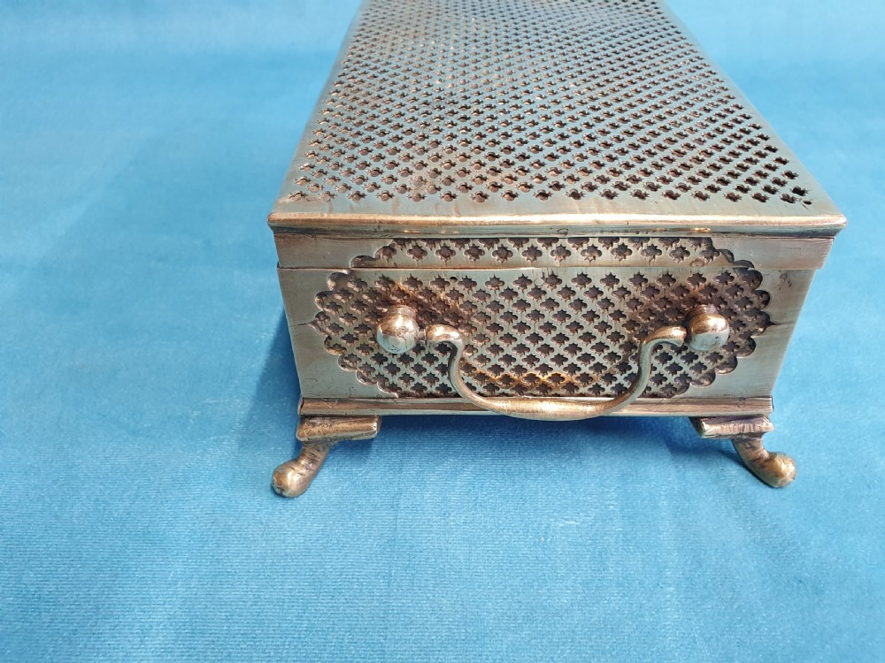 A late nineteenth-century rectangular brass jewellery box featuring pierced lattice fretwork, small corner feet, and a front keyhole. View VII