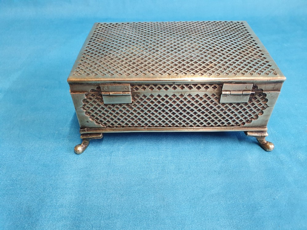 A late nineteenth-century rectangular brass jewellery box featuring pierced lattice fretwork, small corner feet, and a front keyhole. View VIII