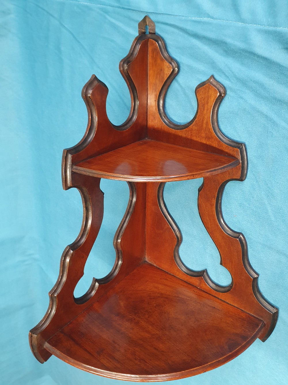 A pair of mid 19th-century mahogany corner wall brackets featuring two triangular display shelves supported by shaped scrollwork fretwork side panels. View V