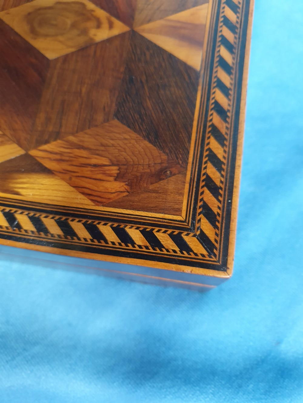 A 19th-century rectangular wooden writing slope featuring geometric tumbling block parquetry inlay and a brass keyhole escutcheon. View II