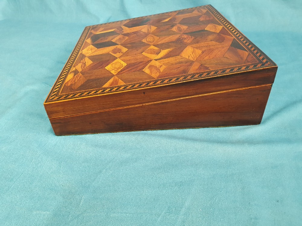 A 19th-century rectangular wooden writing slope featuring geometric tumbling block parquetry inlay and a brass keyhole escutcheon. View VI