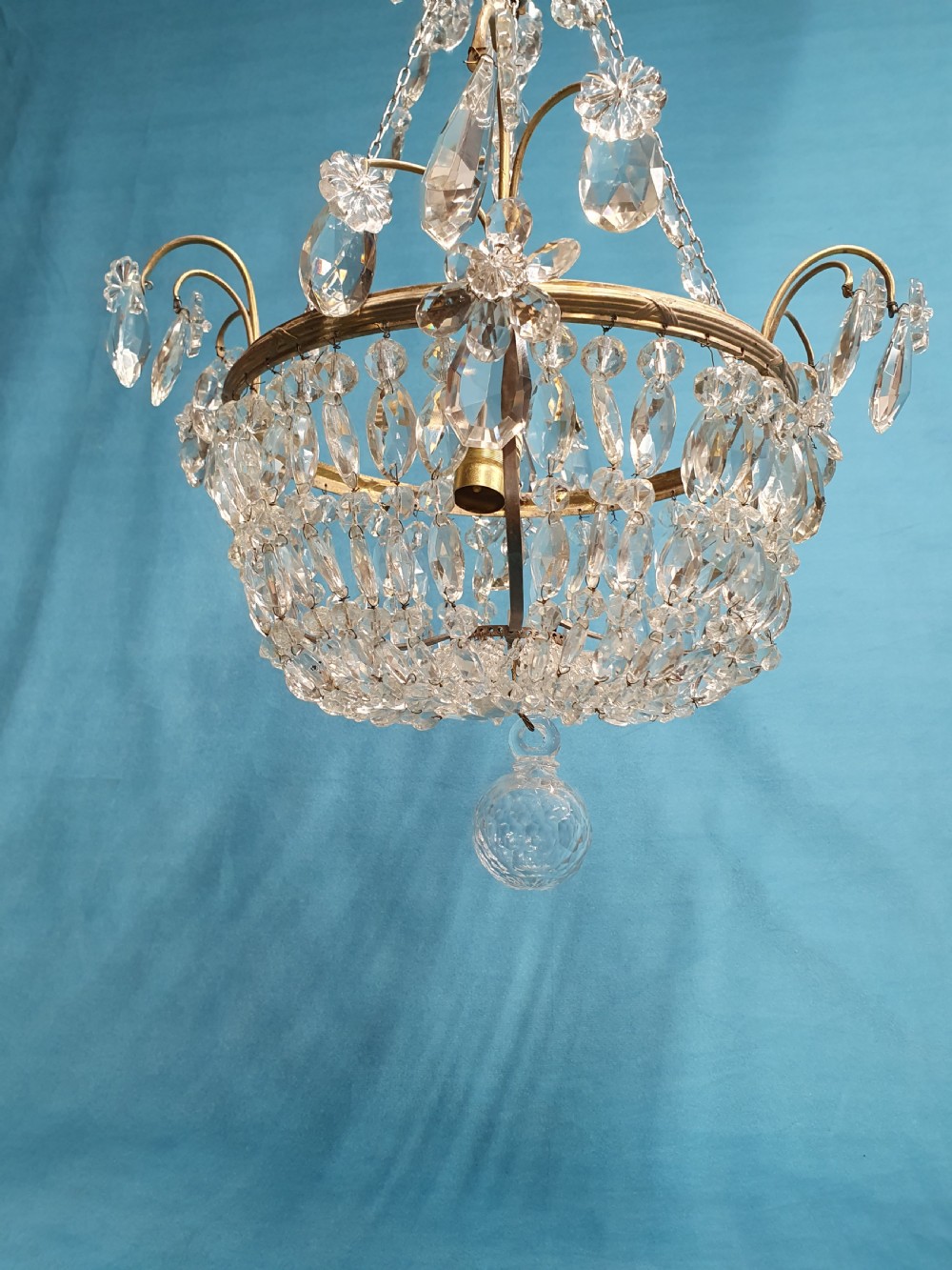 An early 20th-century ceiling chandelier featuring a brass frame hung with cascading cut glass beads forming a basket shape, crowned with scrolled arms holding glass droplets. View III