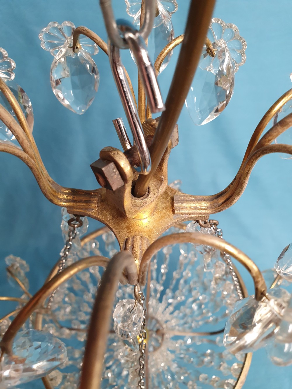 An early 20th-century ceiling chandelier featuring a brass frame hung with cascading cut glass beads forming a basket shape, crowned with scrolled arms holding glass droplets. View VII