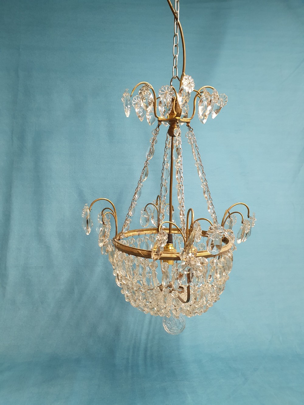 An early 20th-century ceiling chandelier featuring a brass frame hung with cascading cut glass beads forming a basket shape, crowned with scrolled arms holding glass droplets. View XI