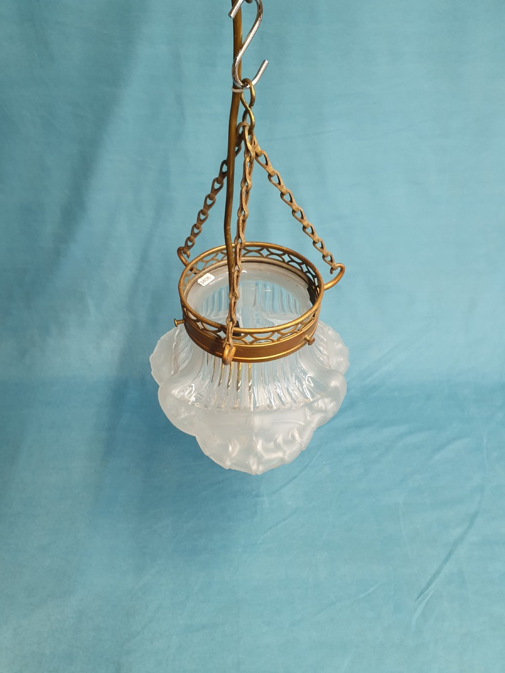 An early 20th-century glass pendant light with a frosted and moulded glass shade suspended by brass chains from a decorative brass gallery. View VI