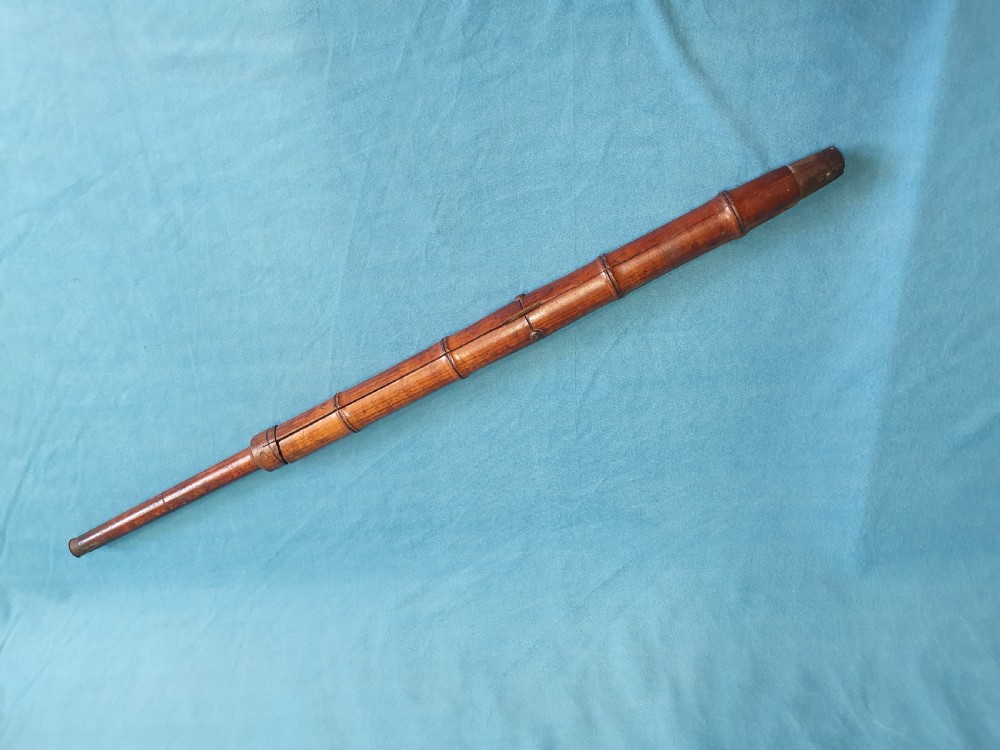 An antique cherry wood folding rod rest featuring carved faux bamboo turnings and a crossed X-frame structure. View II