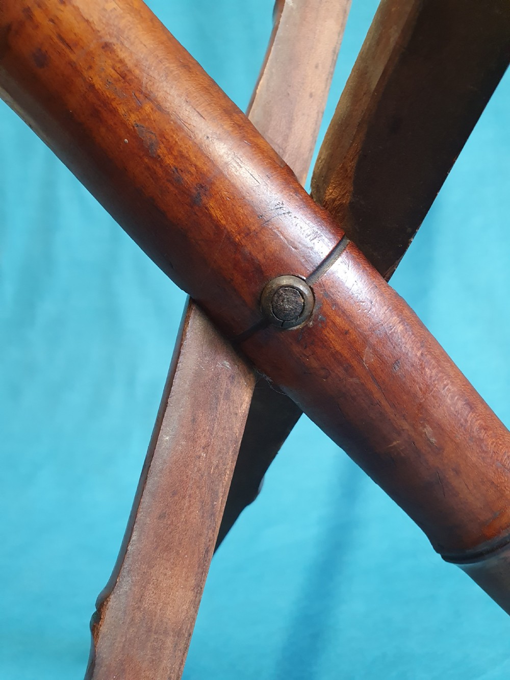 An antique cherry wood folding rod rest featuring carved faux bamboo turnings and a crossed X-frame structure. View VI