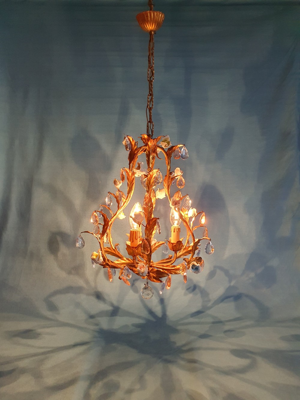 A French gilt metal chandelier and two matching two-arm wall sconces decorated with multi-coloured porcelain flowers and tinted crystal drops. View IV
