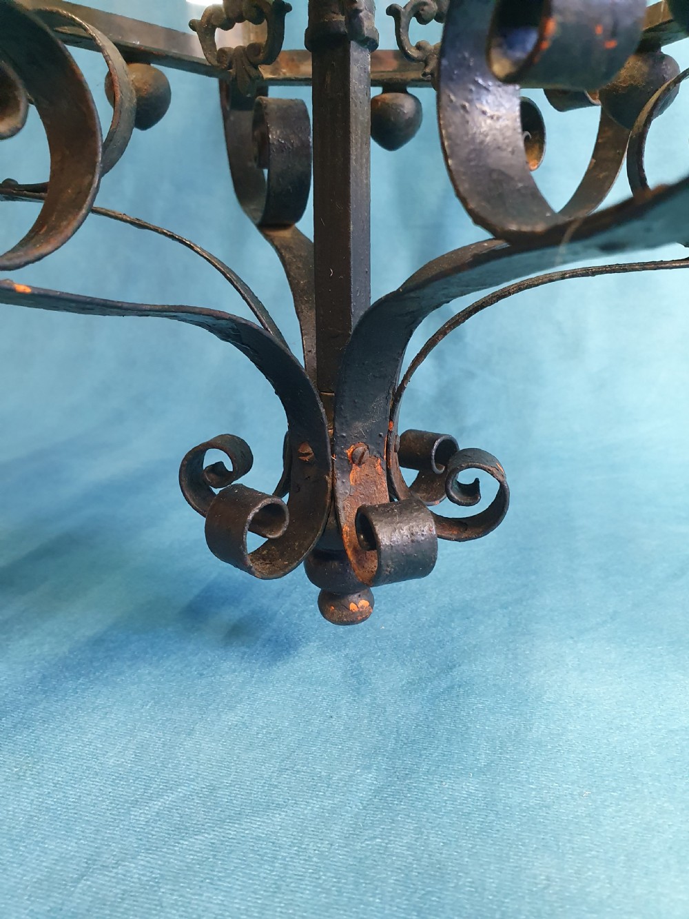 An early 20th-century wrought steel hanging porch lantern featuring elaborate scrollwork, leaf accents, clear glass panels, and an internal multi-bulb light fitting. View VII