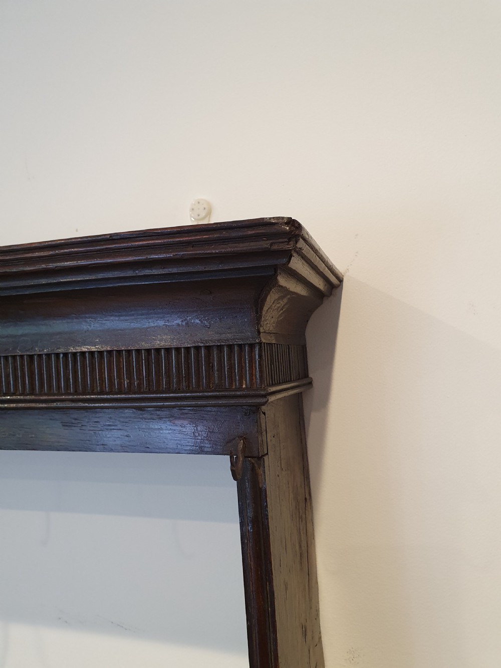 Dark oak early eighteenth-century dresser rack featuring a projecting moulded cornice, three open shelves, and small metal cup hooks. View II