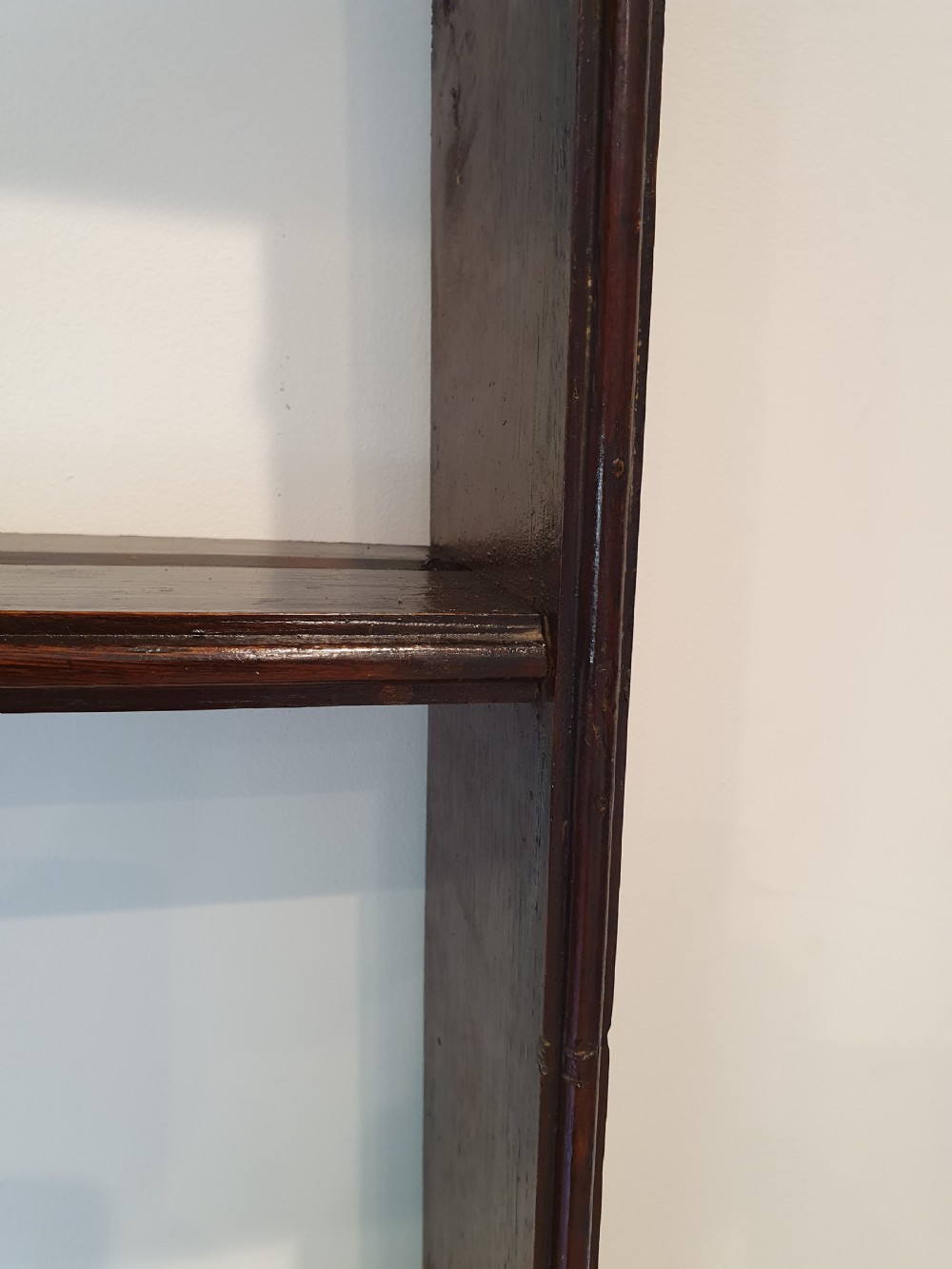 Dark oak early eighteenth-century dresser rack featuring a projecting moulded cornice, three open shelves, and small metal cup hooks. View IV