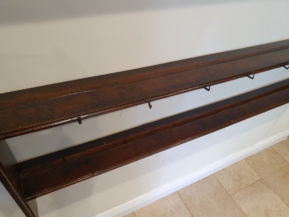 Dark oak early eighteenth-century dresser rack featuring a projecting moulded cornice, three open shelves, and small metal cup hooks. View VII