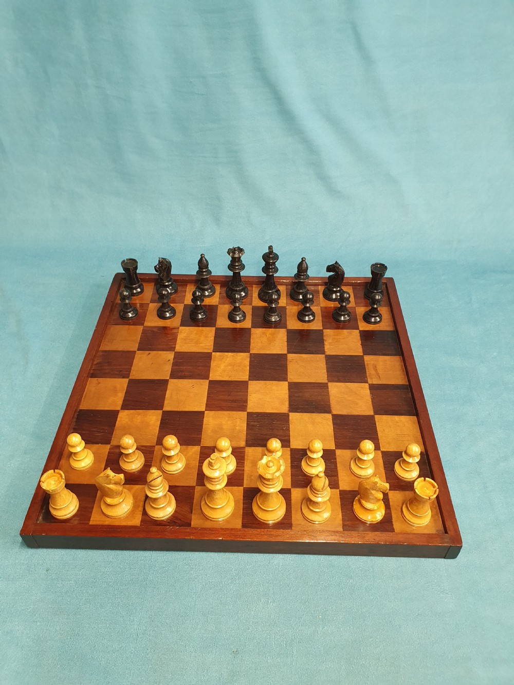 Late 19 century wooden chessboard with early 20th century chess set 