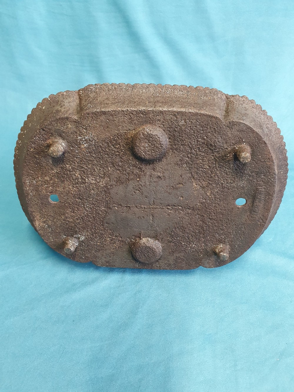 A 19th-century cast iron boot scraper featuring a dished oval tray base and two ornate scrollwork side supports holding a central scraping blade. View V