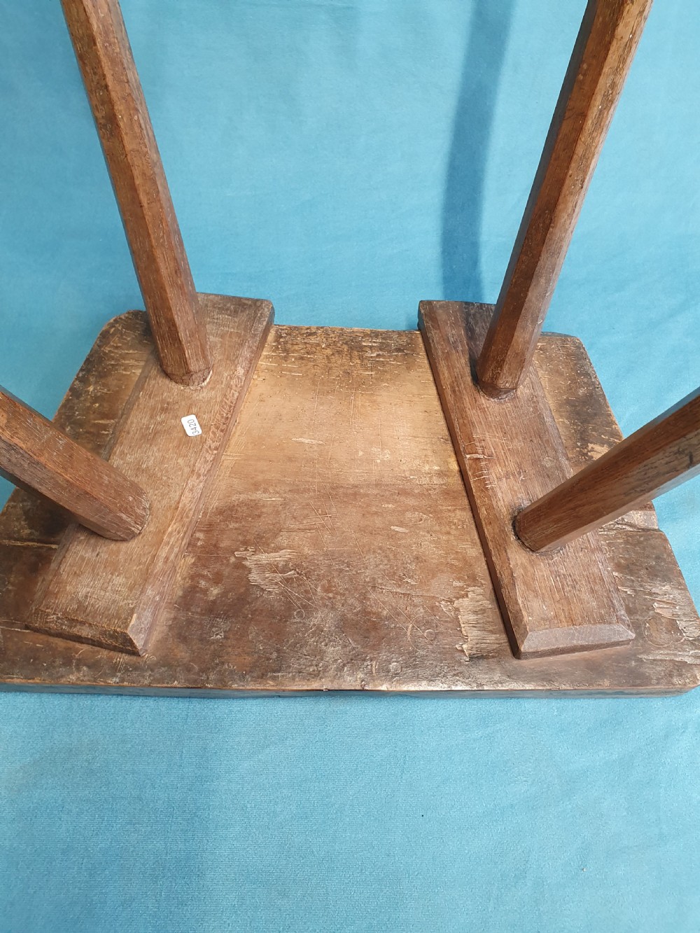 A late 19th-century walnut stick stool featuring a rectangular thick wooden seat raised on four round splayed legs. View II