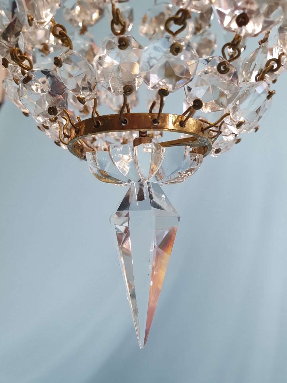 An early 20th-century small swag chandelier featuring a gilt brass frame draped with crystal beads and hanging faceted prisms. View II