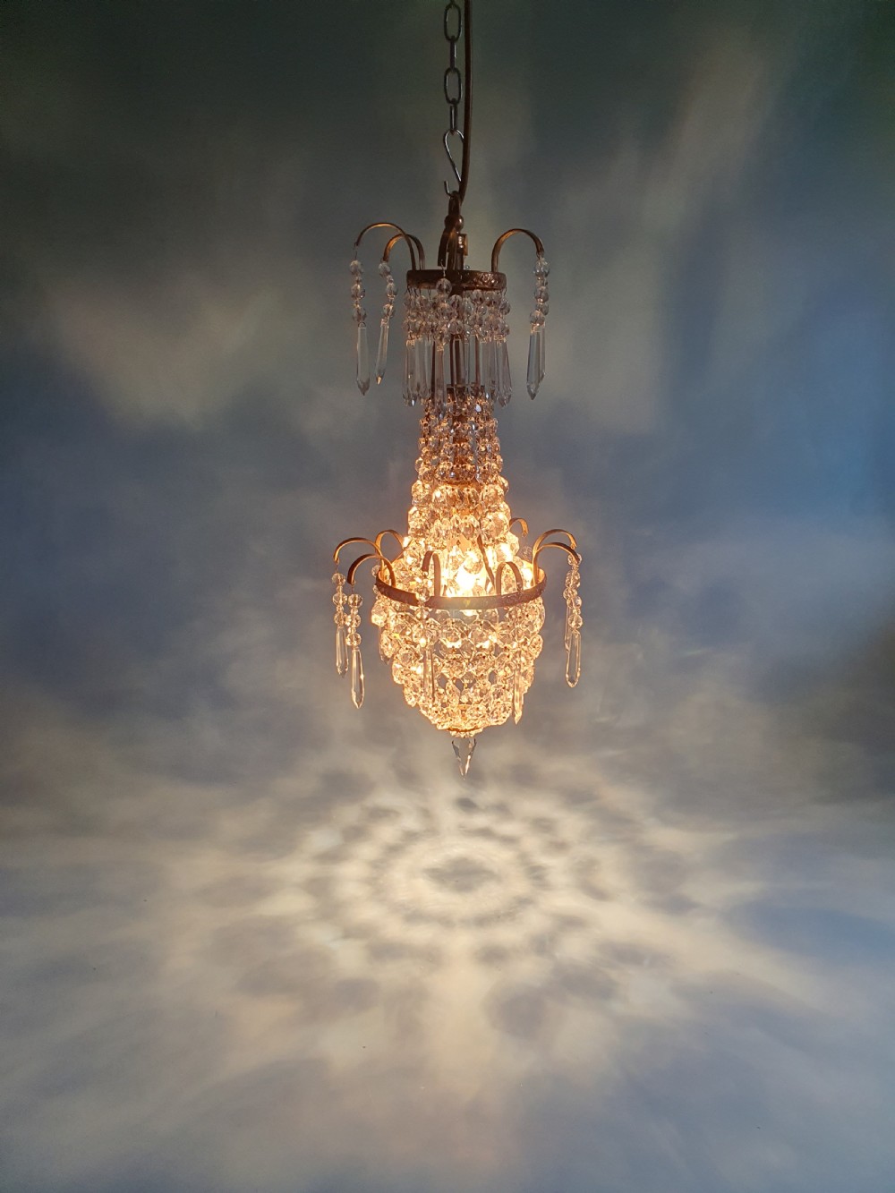 An early 20th-century small swag chandelier featuring a gilt brass frame draped with crystal beads and hanging faceted prisms. View VIII