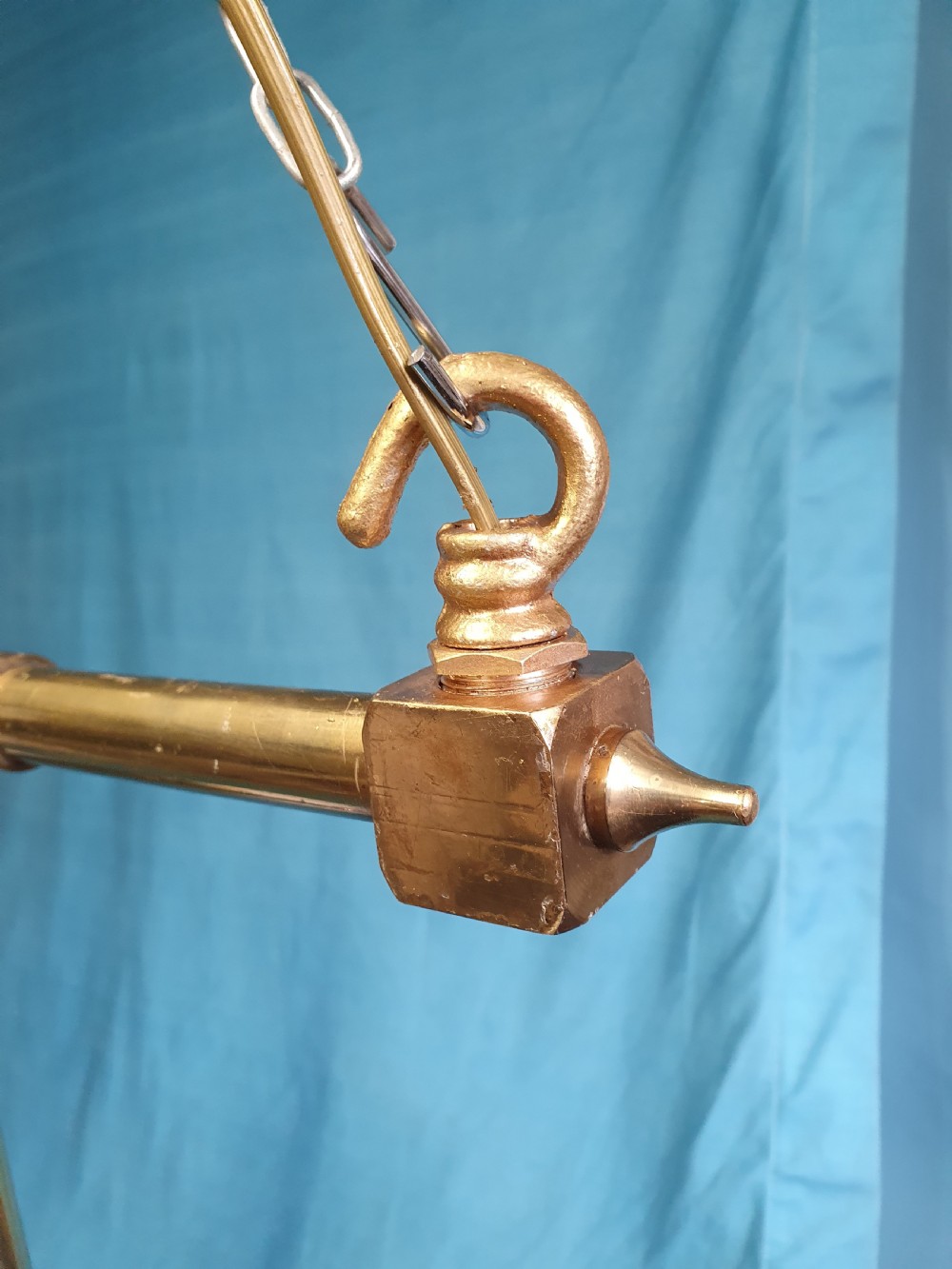 An early 20th-century Gothic Revival linear brass chandelier featuring a horizontal bar structure with ornate scrollwork brackets and two suspended white opaline glass globes. View II
