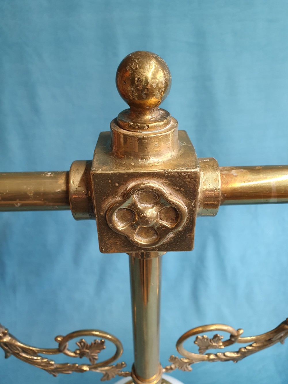 An early 20th-century Gothic Revival linear brass chandelier featuring a horizontal bar structure with ornate scrollwork brackets and two suspended white opaline glass globes. View V