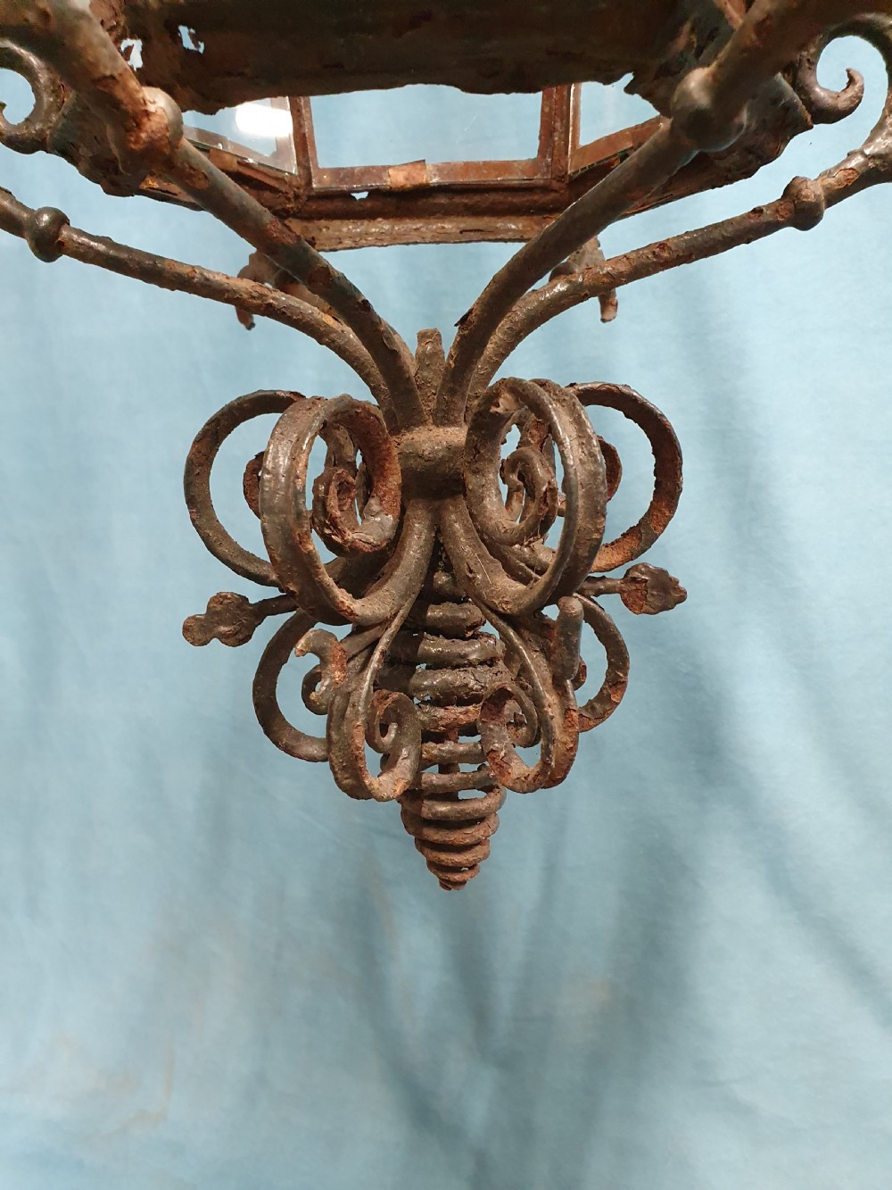 A late 19th-century wrought iron hanging lantern featuring decorative scrollwork, shamrock cutouts along the top canopy, and clear glass side panels. View II