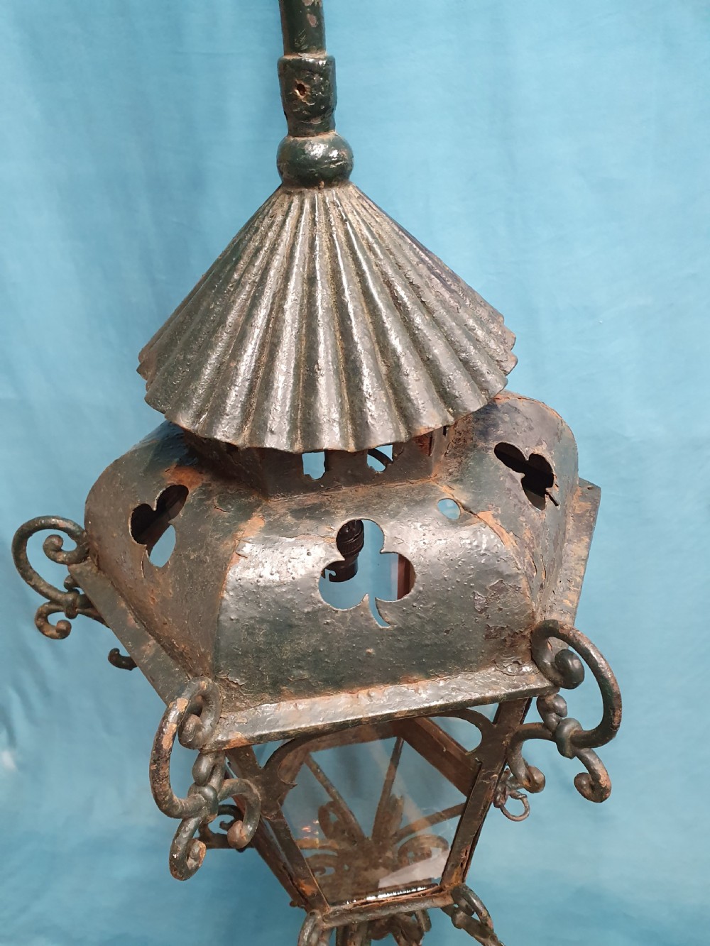 A late 19th-century wrought iron hanging lantern featuring decorative scrollwork, shamrock cutouts along the top canopy, and clear glass side panels. View VIII