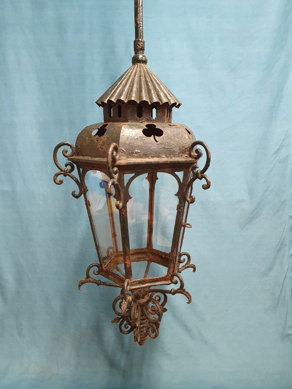 A late 19th-century wrought iron hanging lantern featuring decorative scrollwork, shamrock cutouts along the top canopy, and clear glass side panels. View IX