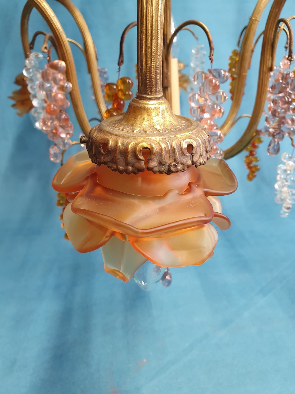 A French brass chandelier adorned with multi-coloured glass grape clusters, scrollwork arms, floral glass cups, and white lampshades. View IX